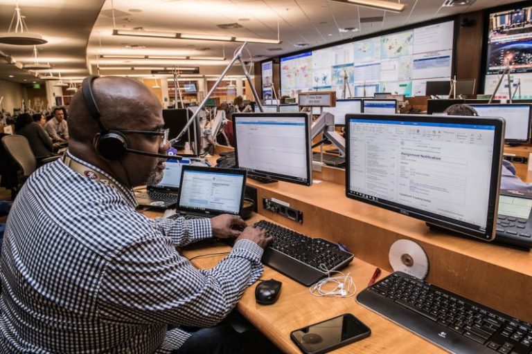 Emergency Response - man in black and white checkered dress shirt using computer