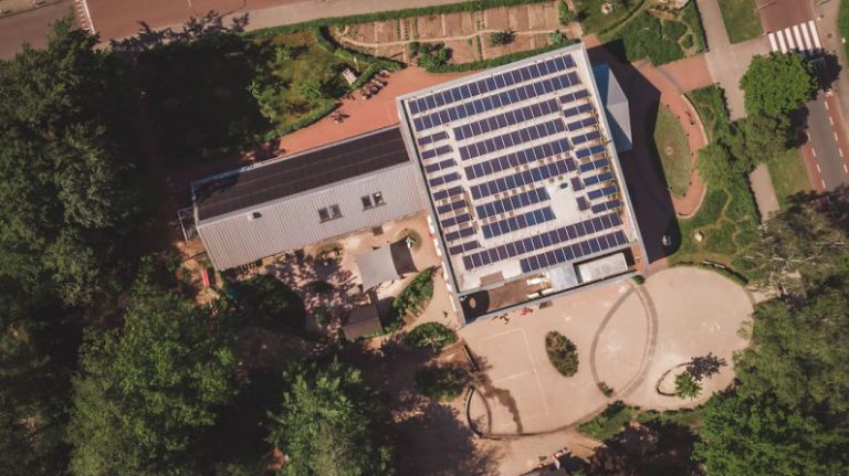 Solar Panels School - an aerial view of a building with solar panels on the roof