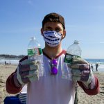 Beach Cleanup - man in white shirt holding bottled water