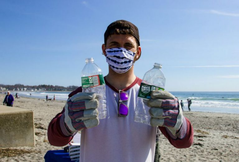 Beach Cleanup - man in white shirt holding bottled water