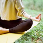 Outdoor Yoga - woman in brown long sleeve shirt and black pants sitting on white textile