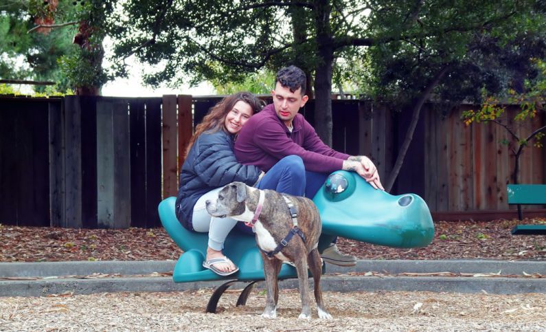 Foster Pets - a man and woman sitting on a bench with a dog