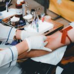 Blood Donation - person in white long sleeve shirt sitting on chair