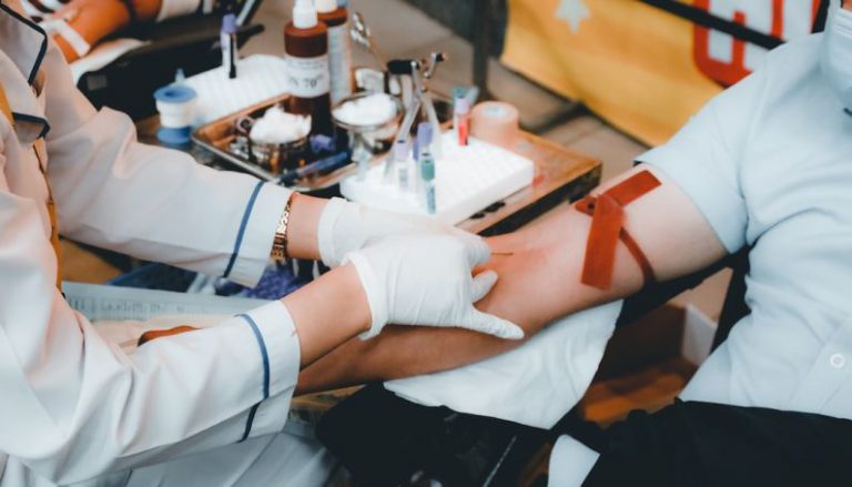 Blood Donation - person in white long sleeve shirt sitting on chair