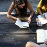 Volunteer Group - woman reading book while sitting on chair