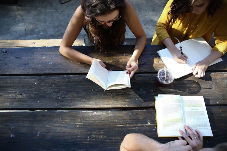 Volunteer Group - woman reading book while sitting on chair