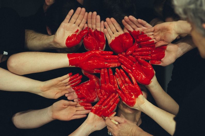 Community Art - hands formed together with red heart paint