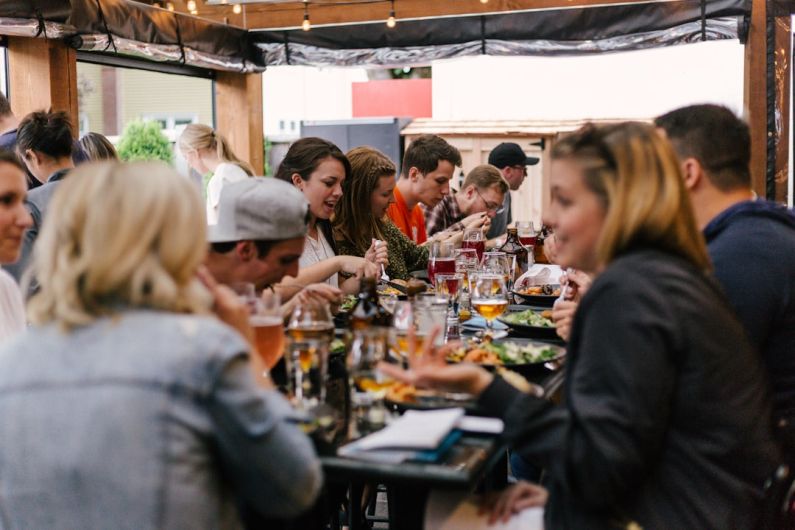 Social Causes - people sitting in front of table talking and eating