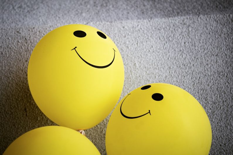 Positivity - yellow smiley emoji on gray textile